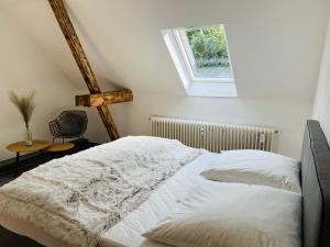 a white bed in a room with a window at Deich Quartier 9.2 in Dorum Neufeld