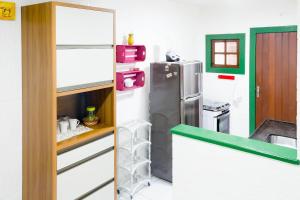 a kitchen with a refrigerator and a counter top at Central Flat 2 quartos - Centro de Búzios in Búzios