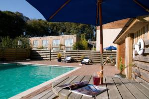 una sombrilla azul sentada en una mesa junto a una piscina en Sennen, en Budock Water