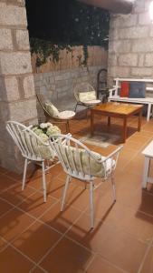 un patio con 2 sillas, una mesa y una mesa en Casa rural El Abuelo Arturo en Becerril de la Sierra