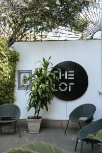 a sign on a wall with chairs and a plant at The Lot Boutique in Lima