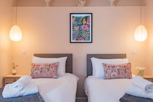 two beds in a room with two pillows at The Parlour by Bloom Stays in Stalisfield