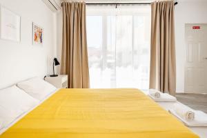 a bedroom with a large yellow bed with a window at Sintra Studio Garden - Free Parking in Sintra