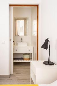 a white bathroom with a sink and a mirror at Sintra Studio Garden - Free Parking in Sintra