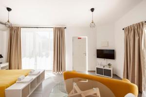 a living room with a yellow couch and a tv at Sintra Studio Garden - Free Parking in Sintra