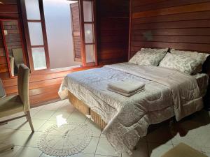 1 dormitorio con 1 cama, 1 silla y ventanas en Família Capetti, en Bauru