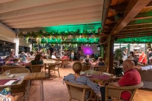 a group of people sitting at tables in a restaurant at Hotel Gala in Noja