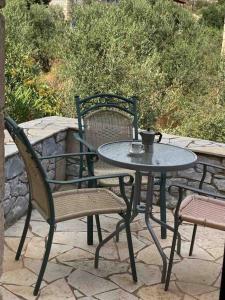 una mesa con dos sillas y una mesa con una taza. en Nikkis house in Stoupa, close to all amenities, en Stoupa
