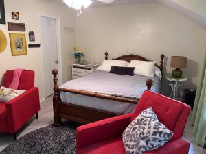 a bedroom with a bed and a red chair at Centrally Located Resort in The High Country RELAX in Newland