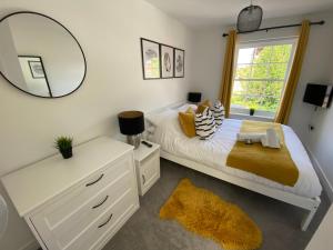 a bedroom with a white bed and a mirror at Lilypad A central location to explore the New Forest & South Coast in Ringwood