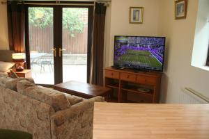 a living room with a couch and a flat screen tv at Coynant Farm Guesthouse - Farm Park Stay in Swansea
