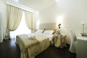 sypialnia z dużym łóżkiem i oknem w obiekcie Caesar Place w Rzymie