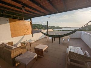 a balcony with a hammock and a view of the water at Casa Monte Luna in Taganga