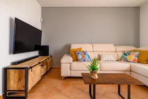 salon z kanapą i telewizorem z płaskim ekranem w obiekcie Villa Twins w mieście Lajares