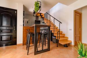 a kitchen with stairs and a bar with stools at Villa Twins in Lajares +29 photos