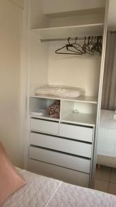 een slaapkamer met een bed en een dressoir in een kast bij FlatsRose CH Flamboyant Conforto e qualidade in Goiânia