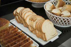 a table topped with bread and a basket of pastries at Hotel Esmeralda Verde in Teófilo Otoni