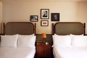 a bedroom with two beds and a table with a lamp at Berkshires Untold in Lenox