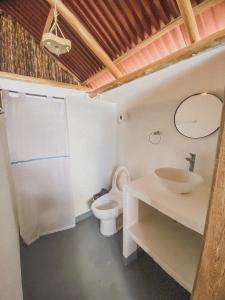 a bathroom with a white toilet and a sink at Mamallena Beachside Rincon del Mar in Rincón