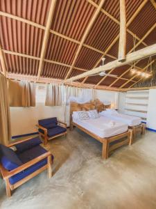 Cette chambre comprend 2 lits et une chaise. dans l'établissement Mamallena Beachside Rincon del Mar, à Rincón