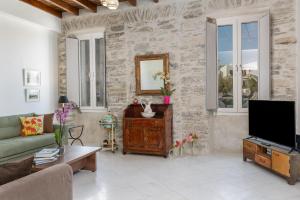 un soggiorno con divano e TV di Ma mer a Naxos Chora