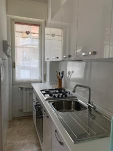 uma cozinha branca com um lavatório e um fogão em Appartamento Sandro by PortofinoVacanze em Rapallo
