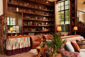 a living room with a couch and chairs and bookshelves at Life House, Berkshires in Lenox