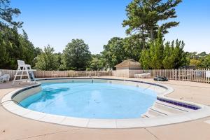 - une grande piscine dans une cour avec une clôture en bois dans l'établissement Sea Colony - Lakeshore, à Bethany Beach