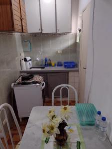 kuchnia ze stołem z kwiatami w obiekcie Kitnet em Frente a Praia w mieście Santos