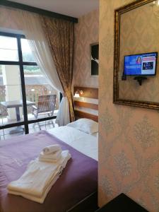 a hotel room with a bed with a mirror and a tv at Шале Золота пiдкова та рiчка in Slavske