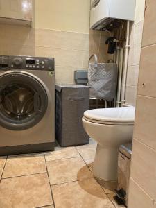 ein Badezimmer mit einer Waschmaschine und einem WC in der Unterkunft Cool Place 02 Academy in London