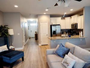 a living room with a couch and a kitchen at ENTIRE HOME- Gorgeous 3br Townhome Pool, Grill, Washer, Dryer, 2 FREE drive up spaces Sleeps 6 Close to everything PCB! in Panama City Beach