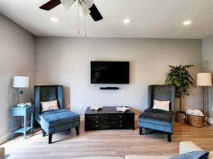 - un salon avec deux chaises et une télévision à écran plat dans l'établissement ENTIRE HOME- Gorgeous 3br Townhome Pool, Grill, WD, 2 FREE drive up spaces Sleeps 6 Close to everything PCB! Free WiFi, à Panama City Beach
