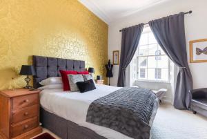 a bedroom with a large bed and a window at Heart of Ayr: elegant townhouse in central Ayr in Ayr