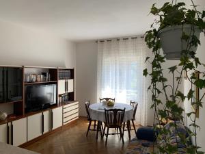 ein Wohnzimmer mit einem Tisch und einem TV in der Unterkunft Appartamento Alba in Riva del Garda
