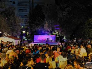 una multitud de personas sentadas en sillas mirando un escenario en Hotel Caravel Park en Rímini