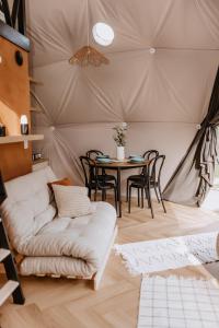 a room with a couch and a table in a tent at Czorsztyn Glamp in Maniowy
