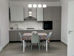 a kitchen with a table with chairs and a sink at A casa di Maria in Marsala