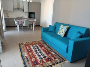 a blue couch in a living room with a kitchen at A casa di Maria in Marsala