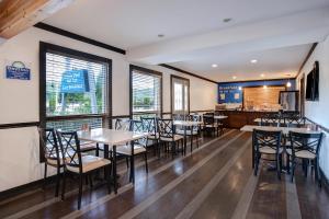 un comedor con mesas, sillas y ventanas en Days Inn by Wyndham Vernon, en Vernon