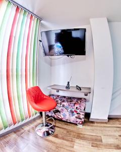 una silla roja en una habitación con TV en MINISUITES Centro Pasto en Pasto