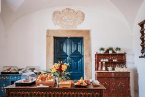 a kitchen with a table with fruit and a blue door at O Conventinho in Évora