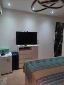 a bedroom with a bed and a flat screen tv at Apartamento em flores in Manaus +1 photo