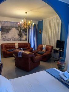 Torrevecchia Teatina的住宿－B&B Portobello，客厅配有棕色皮革家具和吊灯。