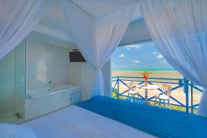 a bedroom with a bed and a view of the ocean at Sollaris Ecopousada in Japaratinga
