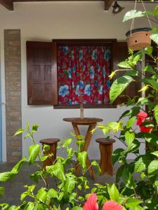 una cortina en una ventana con una mesa y algunas plantas en Pousada Casa de Naue - Ilha de Boipeba, en Isla de Boipeba