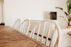 d'une table à manger entourée de chaises blanches. dans l'établissement ALDAPA Casa Rural, à Laguardia