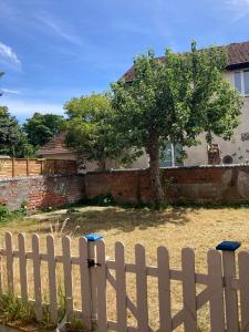 a white fence in front of a house with a tree at Dukes Place sleeps 10 comfortably in Wolverhampton