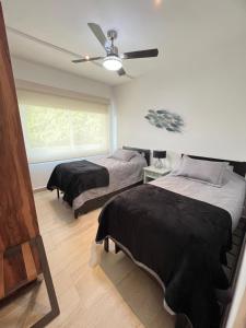 um quarto com 2 camas e uma ventoinha de tecto em Listos enero 2024 Club de Playa gratis albercas em Acapulco