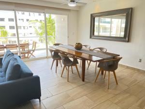 a dining room with a table and chairs and a couch at Nuevo 3R 3B 1E Club Playa Gratis Tenis Padel Diamante Albercas in Acapulco